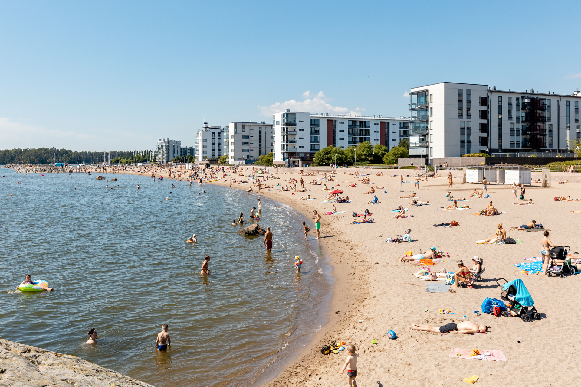 Aurinkolahden uimaranta ja takana näkyviä kerrostaloja.